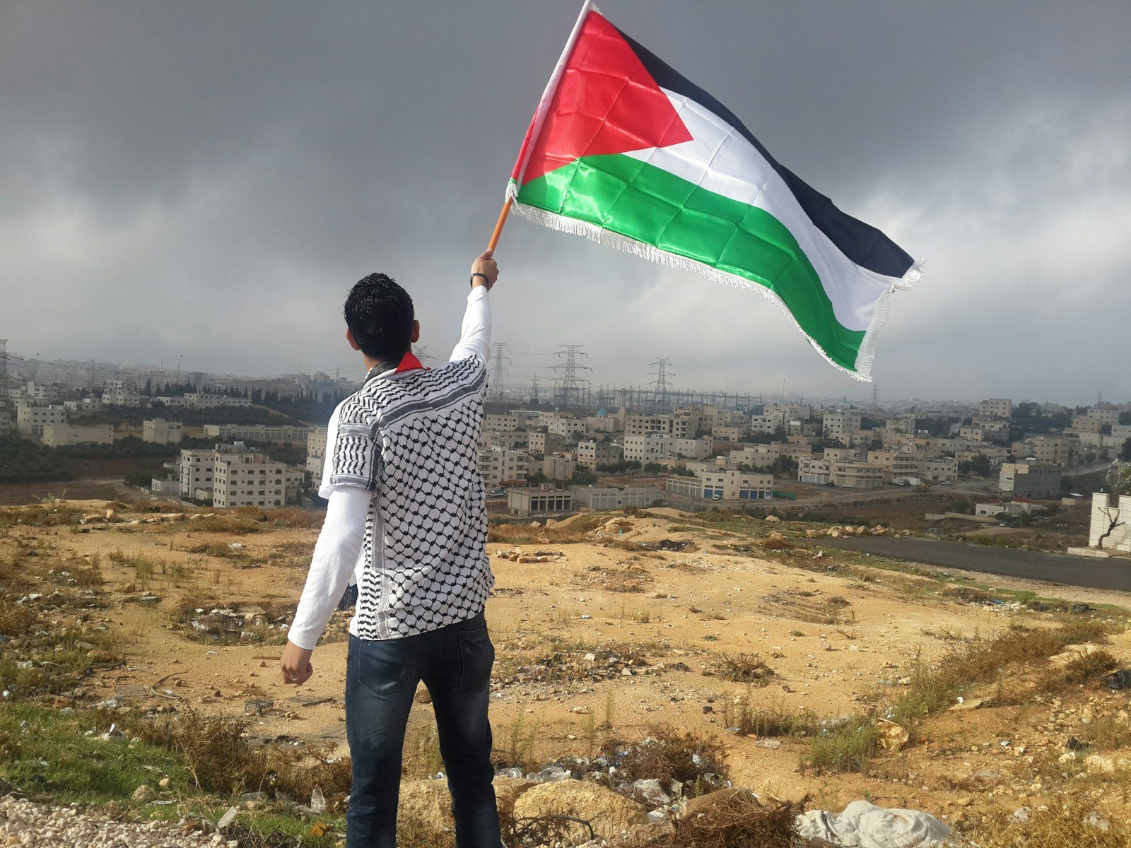 man waving palestinian flag